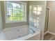Bright bathroom featuring a soaking tub next to a large window and a glass shower at 4061 Preserve Trl, Snellville, GA 30039