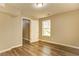 Bedroom showing wood flooring, natural light from the window, and a view into an open doorway at 4061 Preserve Trl, Snellville, GA 30039