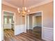 A dining room featuring wood floors, chair rails, and an elegant chandelier at 4061 Preserve Trl, Snellville, GA 30039