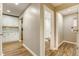 Hallway view showcasing modern flooring, neutral walls, and access to a bathroom and laundry room at 4061 Preserve Trl, Snellville, GA 30039