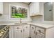 Bright kitchen featuring white cabinets, countertops and faux window view at 4061 Preserve Trl, Snellville, GA 30039