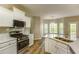 Bright kitchen featuring white cabinets, stainless steel appliances, and a large sink overlooking backyard at 4061 Preserve Trl, Snellville, GA 30039