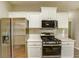 Kitchen featuring stainless steel appliances, white cabinets, quartz countertops and tile backsplash at 4061 Preserve Trl, Snellville, GA 30039