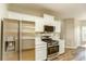 Kitchen featuring stainless steel appliances, white cabinets, quartz countertops and tile backsplash at 4061 Preserve Trl, Snellville, GA 30039