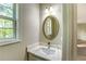 Half bathroom with vanity with white marble countertop, decorative light fixture and large mirror at 4061 Preserve Trl, Snellville, GA 30039
