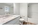 Bright bathroom features granite counters, white vanity, and tub/shower at 1152 Bailing Dr, Lawrenceville, GA 30043