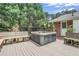 Backyard featuring a hot tub surrounded by a deck, seating, and mature trees, offering a private and relaxing space at 5306 Corinth Cir, Stone Mountain, GA 30087