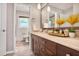 Well-lit bathroom with a dark wood vanity, a long countertop, and a decorative mirror at 5306 Corinth Cir, Stone Mountain, GA 30087
