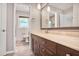 Well-lit bathroom with a dark wood vanity, a long countertop, and a decorative mirror at 5306 Corinth Cir, Stone Mountain, GA 30087