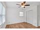 Comfortable bedroom with a ceiling fan, light wood floors, and closet providing ample storage at 5306 Corinth Cir, Stone Mountain, GA 30087