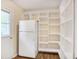 Spacious walk-in pantry with ample white shelving and adjacent refrigerator offers plenty of storage solutions at 5306 Corinth Cir, Stone Mountain, GA 30087