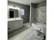 Bright bathroom with vanity, tub, shower, new fixtures, and decorative tile at , Covington, GA 30014