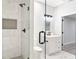 Stylish bathroom featuring white marble-style tile, black hardware, and frameless glass shower at 100 Little Ridge Rd, Berkeley Lake, GA 30096