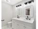 Modern bathroom with a double sink vanity, a toilet, and modern light fixtures at 100 Little Ridge Rd, Berkeley Lake, GA 30096