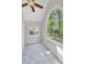 Bedroom with large arched window offering a view of the trees and carpet floors at 100 Little Ridge Rd, Berkeley Lake, GA 30096