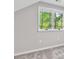 Bedroom featuring neutral carpet, light gray walls, and a window with natural light and green foliage at 100 Little Ridge Rd, Berkeley Lake, GA 30096