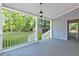 Comfortable covered porch with hanging lantern, views of lush backyard and mature trees at 100 Little Ridge Rd, Berkeley Lake, GA 30096