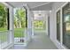 Inviting covered porch with wood floors, white railings, and natural light at 100 Little Ridge Rd, Berkeley Lake, GA 30096
