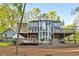 Striking home exterior featuring expansive decks, multiple windows, and wooded landscape, perfect for relaxing outdoor living at 100 Little Ridge Rd, Berkeley Lake, GA 30096