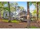 Beautiful exterior featuring a multi-level deck connecting to a detached structure, set amidst mature trees and landscaping at 100 Little Ridge Rd, Berkeley Lake, GA 30096