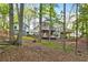Scenic home exterior with expansive decks and a connected structure, nestled among lush trees and natural surroundings at 100 Little Ridge Rd, Berkeley Lake, GA 30096