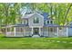 Charming two-story home featuring a covered porch, manicured lawn, and a welcoming entrance at 100 Little Ridge Rd, Berkeley Lake, GA 30096