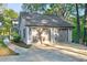 Two-car garage with traditional doors, exterior lighting, and well-maintained grounds at 100 Little Ridge Rd, Berkeley Lake, GA 30096