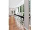 Hallway featuring hardwood floors, white columns, unique railing and windows that provide natural light at 100 Little Ridge Rd, Berkeley Lake, GA 30096