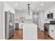 Modern eat-in kitchen features stainless steel appliances, white cabinets and countertops, and hardwood floors at 100 Little Ridge Rd, Berkeley Lake, GA 30096