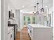 Bright kitchen with white cabinets, an island, stainless steel appliances, and views from a bay window at 100 Little Ridge Rd, Berkeley Lake, GA 30096