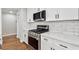 Updated kitchen with stainless steel oven/range, stone countertops, and stylish cabinets at 100 Little Ridge Rd, Berkeley Lake, GA 30096