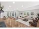 Expansive living room featuring hardwood floors, neutral furniture, stone fireplace and bright windows at 100 Little Ridge Rd, Berkeley Lake, GA 30096