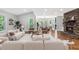Bright open-concept living and dining area with hardwood floors and a stone fireplace at 100 Little Ridge Rd, Berkeley Lake, GA 30096