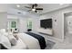 Modern main bedroom featuring a ceiling fan, TV and sitting area with a great view at 100 Little Ridge Rd, Berkeley Lake, GA 30096
