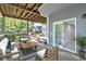Relaxing outdoor covered patio with stylish seating and views of the landscaped yard at 100 Little Ridge Rd, Berkeley Lake, GA 30096