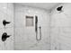 Modern shower featuring marble tile, matte black fixtures, and a built-in shower niche at 100 Little Ridge Rd, Berkeley Lake, GA 30096