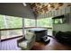 Relaxing screened-in porch with hot tub, comfortable seating, and wooded backyard views at 1080 Gaithers Rd, Mansfield, GA 30055