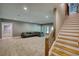 Spacious finished basement with plush carpeting, ample seating, and staircase at 1080 Gaithers Rd, Mansfield, GA 30055
