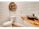 Charming powder room featuring shiplap walls, unique sink basin, and decorative round shelving at 1080 Gaithers Rd, Mansfield, GA 30055