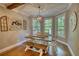 Charming dining room with wooden table and bench seating, complemented by natural light from surrounding windows at 1080 Gaithers Rd, Mansfield, GA 30055