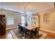 The dining room is illuminated by a chandelier, and furnished with a table, and chairs at 1080 Gaithers Rd, Mansfield, GA 30055