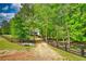 Gravel driveway leading to the home, surrounded by lush greenery and a charming black fence at 1080 Gaithers Rd, Mansfield, GA 30055