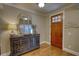 A wooden entry door and a decorative mirror adorn the entryway of this home at 1080 Gaithers Rd, Mansfield, GA 30055