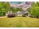 Well-maintained home with a gray exterior, lush greenery, and a serene, tree-lined backdrop at 1080 Gaithers Rd, Mansfield, GA 30055