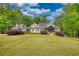 Beautifully landscaped home with a gray exterior, dormer windows, and mature trees in the background at 1080 Gaithers Rd, Mansfield, GA 30055