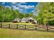 Beautiful home on large lot with black fence, surrounded by lush trees and sky at 1080 Gaithers Rd, Mansfield, GA 30055