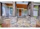 Inviting front porch with stone details, cedar columns, and a warm, wooden front door at 1080 Gaithers Rd, Mansfield, GA 30055