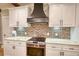 Well-equipped kitchen features white cabinetry, brick backsplash and stainless steel oven and range at 1080 Gaithers Rd, Mansfield, GA 30055