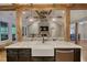 Open-concept living room with farmhouse sink, exposed beams and stone fireplace at 1080 Gaithers Rd, Mansfield, GA 30055