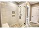 Modern tiled shower with glass door, built-in bench, and pebble floor at 1080 Gaithers Rd, Mansfield, GA 30055